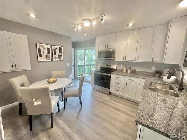 1226 Oakleaf Dr, Saint Louis, MO 63119 - kitchen featuring appliances with stainless steel finishes, white cabinets, dark stone counters, light wood finished floors, and recessed lighting