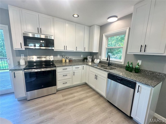 1226 Oakleaf Dr, Saint Louis, MO 63119 - kitchen featuring appliances with stainless steel finishes, white cabinets, dark stone counters, light wood-type flooring, and recessed lighting