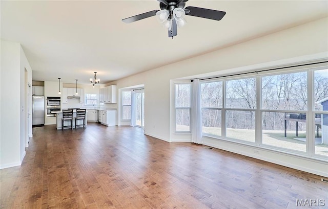17603 Hitching Post Ct, Eureka, MO 63025 - unfurnished living room with dark wood-type flooring, a ceiling fan, and a chandelier
