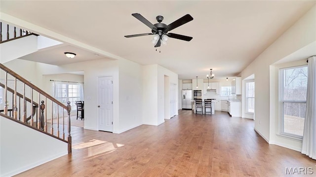 17603 Hitching Post Ct, Eureka, MO 63025 - unfurnished living room featuring stairway, wood finished floors, and ceiling fan