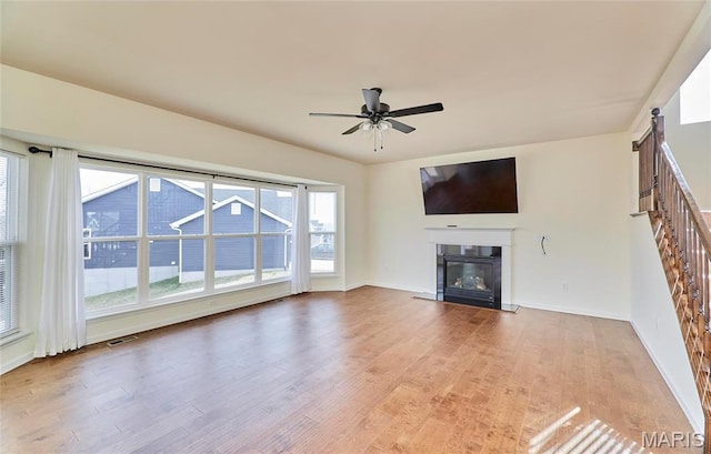 17603 Hitching Post Ct, Eureka, MO 63025 - unfurnished living room with a glass covered fireplace, wood finished floors, and a ceiling fan