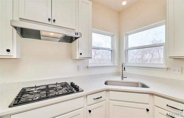 17603 Hitching Post Ct, Eureka, MO 63025 - kitchen featuring under cabinet range hood, gas stovetop, light countertops, and white cabinetry