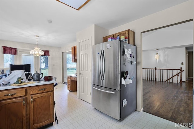 3816 Keeneland Ct, Florissant, MO 63034 - kitchen featuring freestanding refrigerator, a chandelier, light countertops, and brown cabinets
