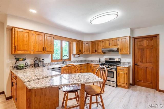 616 E Brentmoor Dr, Troy, IL 62294 - kitchen with appliances with stainless steel finishes, under cabinet range hood, a peninsula, light stone countertops, and a breakfast bar area