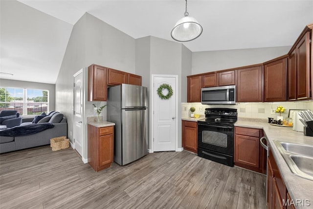 40 Valley Farms Dr, Winfield, MO 63389 - kitchen with appliances with stainless steel finishes, open floor plan, high vaulted ceiling, light countertops, and backsplash