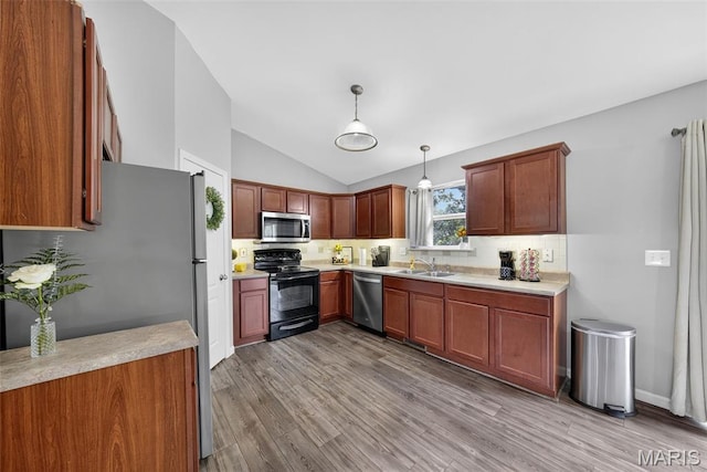 40 Valley Farms Dr, Winfield, MO 63389 - kitchen with stainless steel appliances, decorative backsplash, lofted ceiling, light wood-style flooring, and light countertops