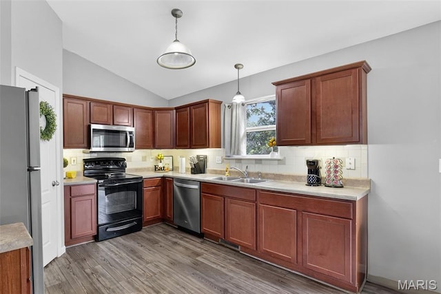 40 Valley Farms Dr, Winfield, MO 63389 - kitchen featuring appliances with stainless steel finishes, lofted ceiling, light wood-style floors, pendant lighting, and decorative backsplash