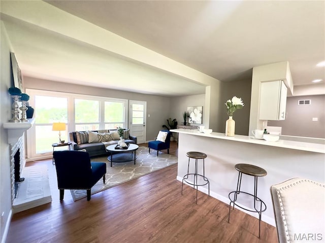 1248 Lynchester Ln, Kirkwood, MO 63122 - kitchen featuring a breakfast bar, white cabinetry, wood finished floors, and light countertops
