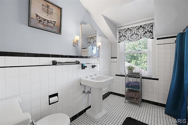 401 Elm St, Washington, MO 63090 - bathroom featuring tile walls, tiled shower, tile patterned flooring, and a wainscoted wall