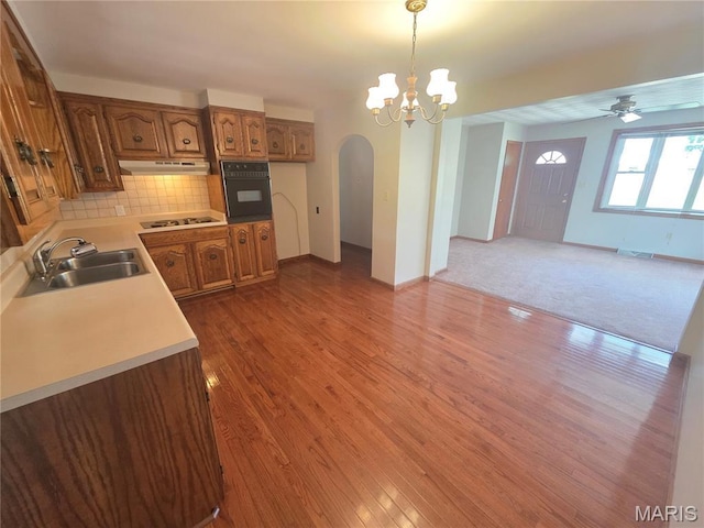 132 Linn Dr, Saint Genevieve, MO 63670 - kitchen featuring black oven, arched walkways, brown cabinets, cooktop, and light countertops