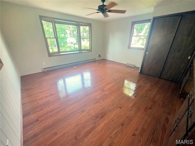 132 Linn Dr, Saint Genevieve, MO 63670 - unfurnished bedroom featuring baseboard heating, wood finished floors, and a ceiling fan