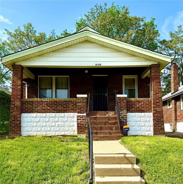 6110 Wyma Ave, Pine Lawn, MO 63120 - view of front facade with covered porch, brick siding, and a front lawn