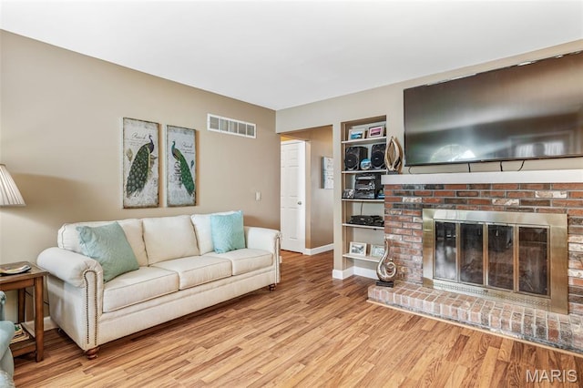5028 Baldcypress Ct, Saint Louis, MO 63128 - living area with light wood finished floors and a brick fireplace
