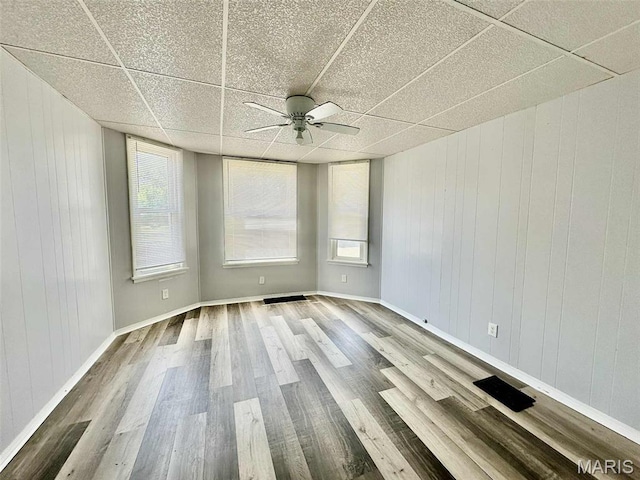 316 Church St, East Alton, IL 62024 - empty room featuring wood finished floors, a drop ceiling, ceiling fan, and wood walls