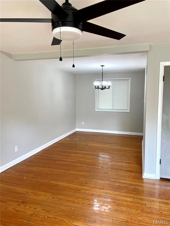9264 Bellefontaine Rd, Bellefontaine Nghbrs, MO 63137 - unfurnished room featuring a ceiling fan, wood finished floors, and a chandelier
