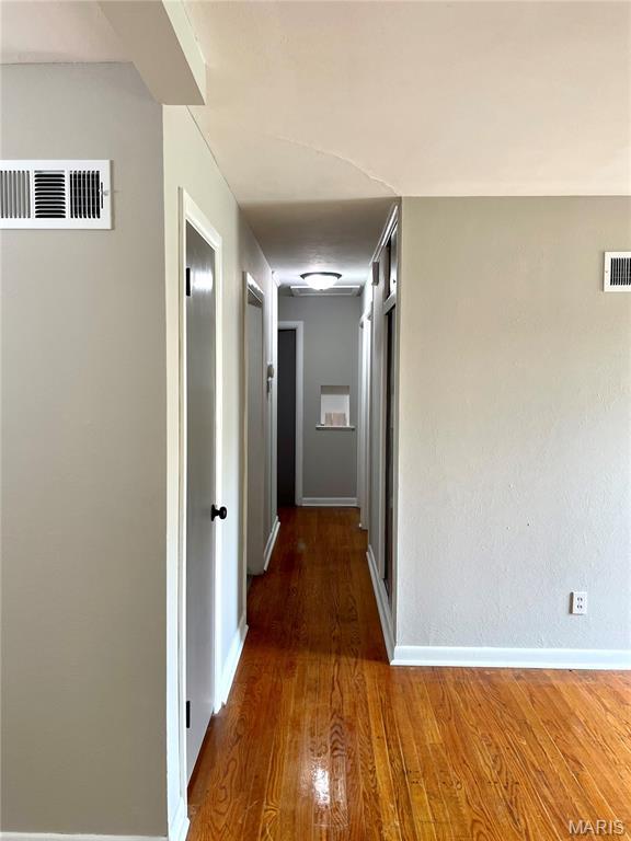 9264 Bellefontaine Rd, Bellefontaine Nghbrs, MO 63137 - hallway featuring wood finished floors and baseboards