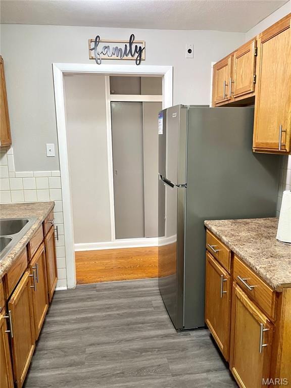 9264 Bellefontaine Rd, Bellefontaine Nghbrs, MO 63137 - kitchen featuring wood finished floors, brown cabinets, and freestanding refrigerator