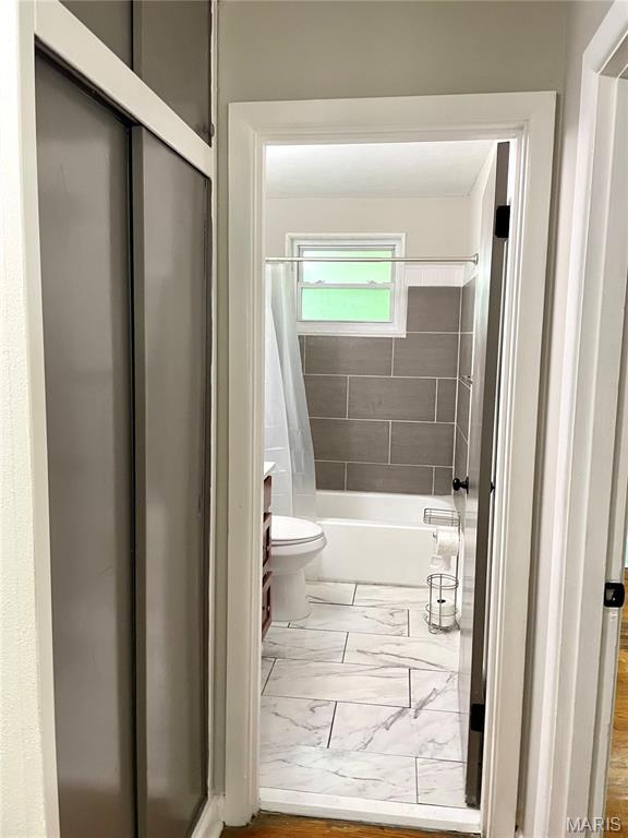 9264 Bellefontaine Rd, Bellefontaine Nghbrs, MO 63137 - bathroom featuring marble finish floors, shower / bathtub combination with curtain, and vanity