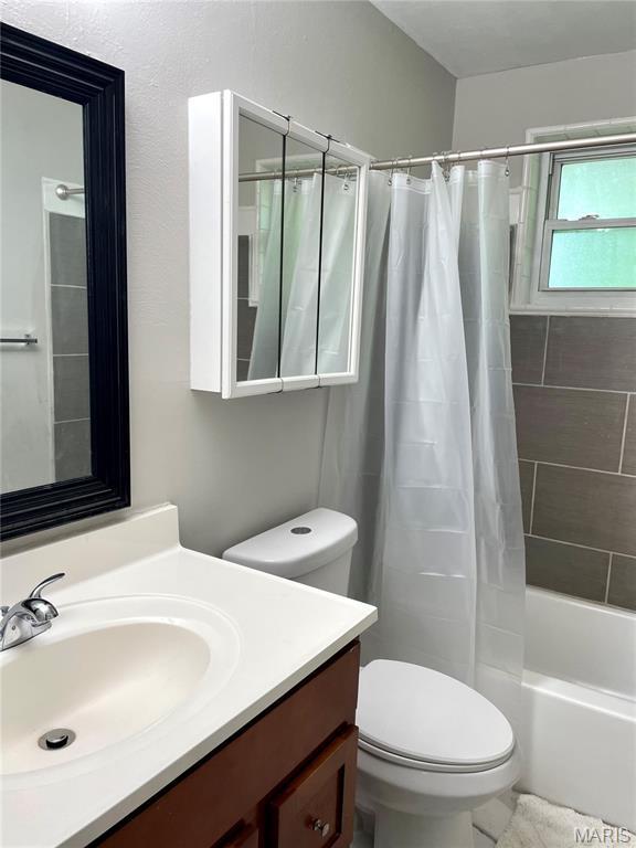 9264 Bellefontaine Rd, Bellefontaine Nghbrs, MO 63137 - bathroom featuring vanity and shower / bathtub combination with curtain
