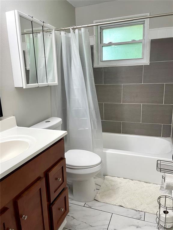 9264 Bellefontaine Rd, Bellefontaine Nghbrs, MO 63137 - bathroom featuring marble finish flooring, vanity, and shower / tub combo