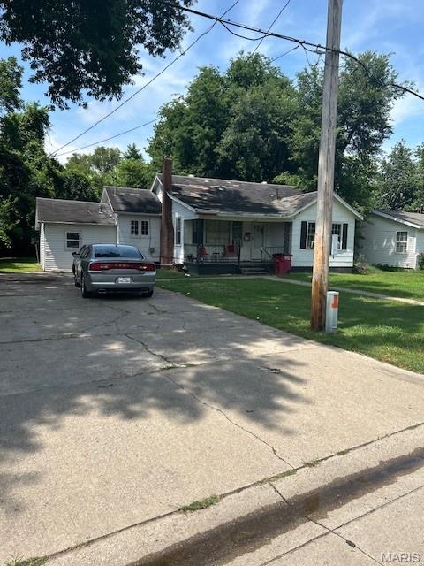 1140 Ruth St, Sikeston, MO 63801 - view of front of property featuring concrete driveway, a porch, and a front yard