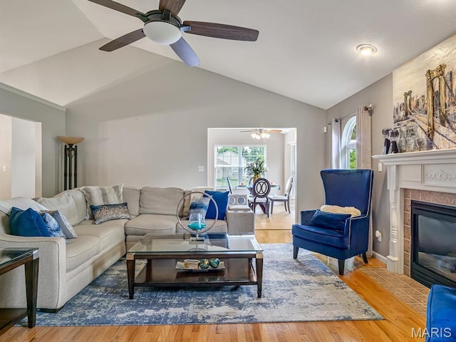 22 Foxmoor Dr, Maryville, IL 62062 - living room featuring lofted ceiling, healthy amount of natural light, a ceiling fan, wood finished floors, and a tiled fireplace