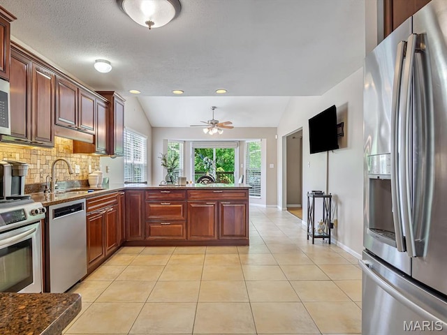 22 Foxmoor Dr, Maryville, IL 62062 - kitchen with appliances with stainless steel finishes, vaulted ceiling, a peninsula, tasteful backsplash, and ceiling fan