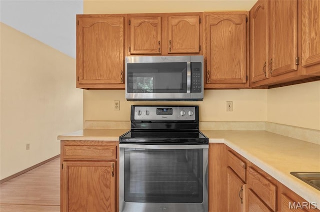 221 James St, Bethalto, IL 62010 - kitchen with stainless steel appliances, light countertops, and light wood-type flooring