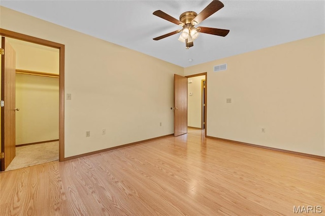 221 James St, Bethalto, IL 62010 - unfurnished bedroom with light wood finished floors, a spacious closet, and a ceiling fan