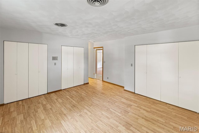 46 Coronation Dr, Millstadt, IL 62260 - unfurnished bedroom featuring two closets and light wood-style flooring
