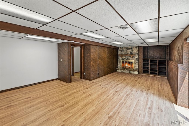 46 Coronation Dr, Millstadt, IL 62260 - finished below grade area with a drop ceiling, wood finished floors, wooden walls, and a stone fireplace