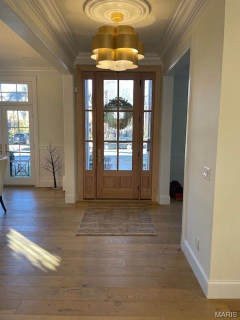 8145 University Dr, Clayton, MO 63105 - foyer featuring hardwood / wood-style flooring, ornamental molding, and a chandelier