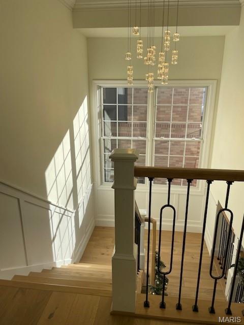 8145 University Dr, Clayton, MO 63105 - stairway with wood finished floors, a chandelier, and healthy amount of natural light