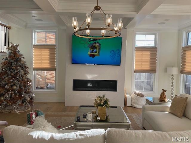 8145 University Dr, Clayton, MO 63105 - living area with coffered ceiling, a chandelier, wood finished floors, a glass covered fireplace, and crown molding