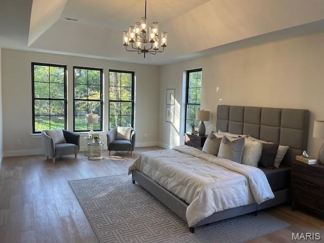 8145 University Dr, Clayton, MO 63105 - bedroom with a chandelier, wood finished floors, and a tray ceiling
