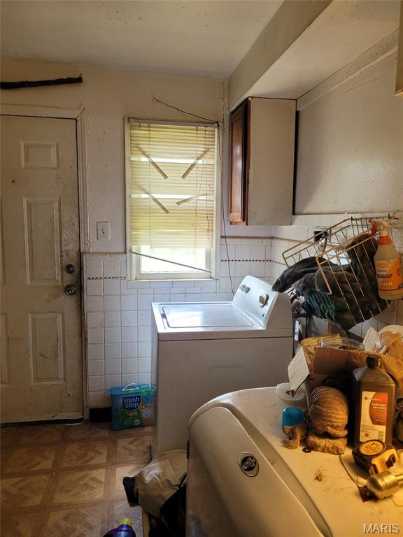 8138 Blanchard Dr, Saint Louis, MO 63134 - laundry area featuring tile walls, independent washer and dryer, and a wainscoted wall