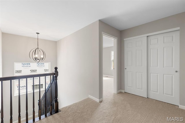 2213 Rule Ave, Maryland Heights, MO 63146 - hallway with an upstairs landing, a chandelier, and carpet floors