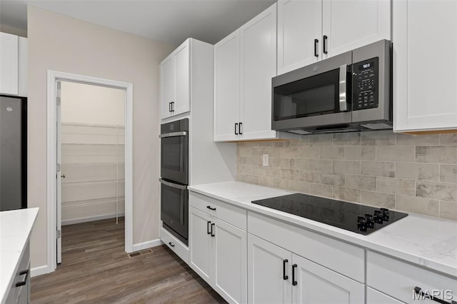 2213 Rule Ave, Maryland Heights, MO 63146 - kitchen featuring stainless steel appliances, white cabinetry, wood finished floors, backsplash, and light stone countertops