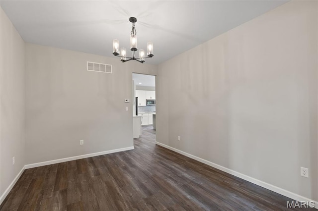 2213 Rule Ave, Maryland Heights, MO 63146 - spare room featuring a chandelier and dark wood-style flooring