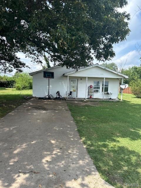 1316 Butler St, Sikeston, MO 63801 - view of front facade with covered porch, a front yard, and driveway