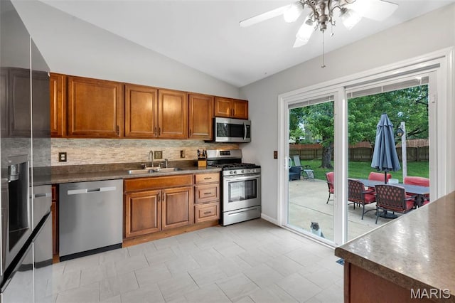15 Ann Dr, Saint Peters, MO 63376 - kitchen with stainless steel appliances, brown cabinets, a ceiling fan, decorative backsplash, and vaulted ceiling