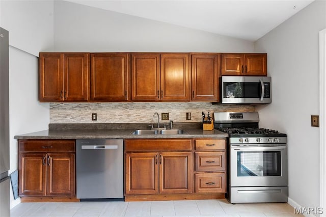 15 Ann Dr, Saint Peters, MO 63376 - kitchen with stainless steel appliances, dark countertops, vaulted ceiling, decorative backsplash, and brown cabinetry
