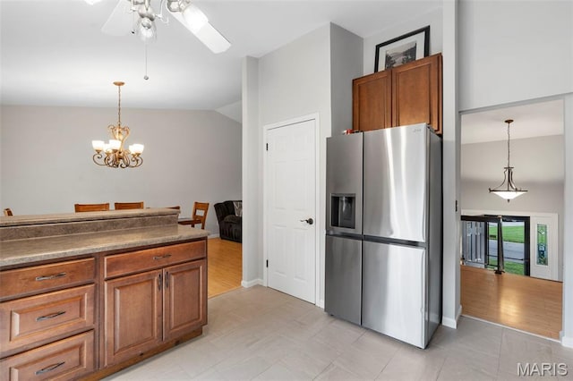15 Ann Dr, Saint Peters, MO 63376 - kitchen featuring stainless steel fridge with ice dispenser, brown cabinetry, ceiling fan, vaulted ceiling, and hanging light fixtures
