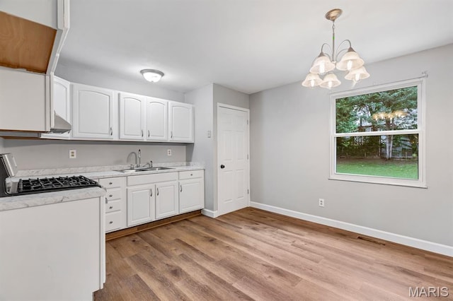 17 Edward Dr, Saint Peters Township, MO 63304 - kitchen featuring light countertops, white cabinetry, wood finished floors, a chandelier, and pendant lighting