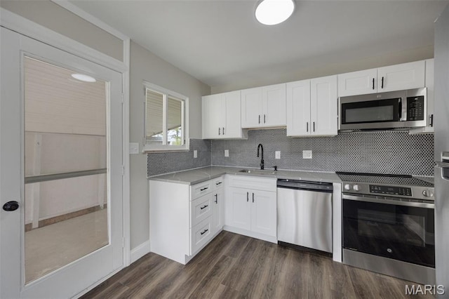 229 Orchard Ave, Ballwin, MO 63021 - kitchen with appliances with stainless steel finishes, decorative backsplash, white cabinets, and dark wood-style flooring