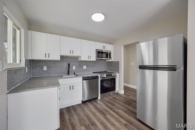 229 Orchard Ave, Ballwin, MO 63021 - kitchen featuring stainless steel appliances, white cabinetry, tasteful backsplash, and dark wood-style floors