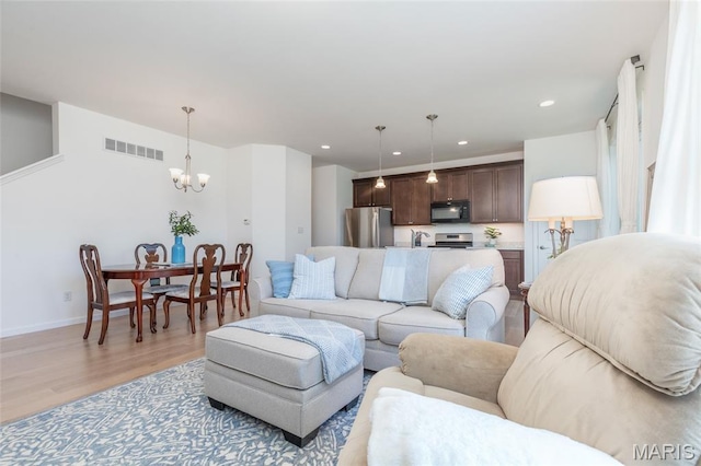9 Vera Pl, Saint Charles, MO 63303 - living room with a chandelier, light wood finished floors, and recessed lighting