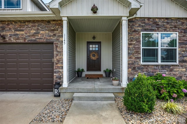 1145 Nassau Dr, Edwardsville, IL 62025 - entrance to property featuring stone siding, board and batten siding, and concrete driveway