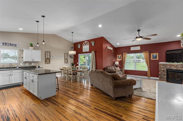 1145 Nassau Dr, Edwardsville, IL 62025 - kitchen featuring open floor plan, wood finished floors, ceiling fan, white cabinetry, and vaulted ceiling