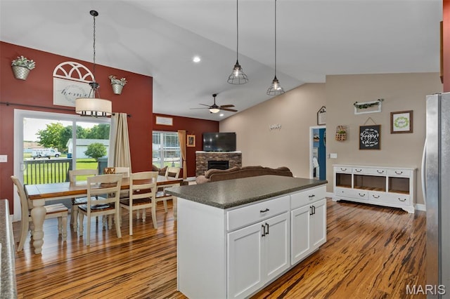 1145 Nassau Dr, Edwardsville, IL 62025 - kitchen featuring dark countertops, a stone fireplace, a ceiling fan, freestanding refrigerator, and wood finished floors